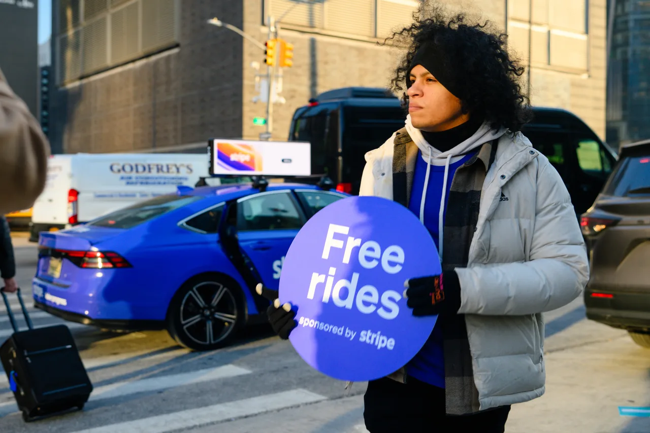 Stripe Free Rides activation in New York City: a wrapped blue vehicle with a Stripe creative on its digital taxi top, and a street team member holding a Free Rides sign