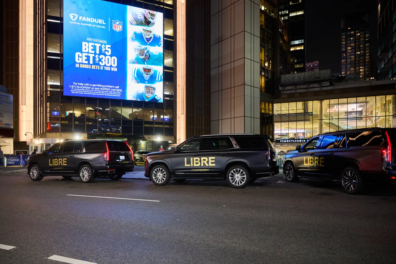 FanDuel digital billboard on Madison Square Garden above the Pennsylvania Station entrance, with Saint Laurent Libre wrapped SUVs below, New York, 2025
